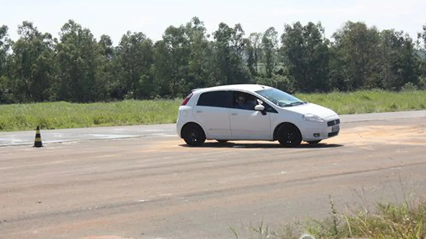 Aluno ao volante em exercício de traçado entre cones no Controle e Dirigibilidade I